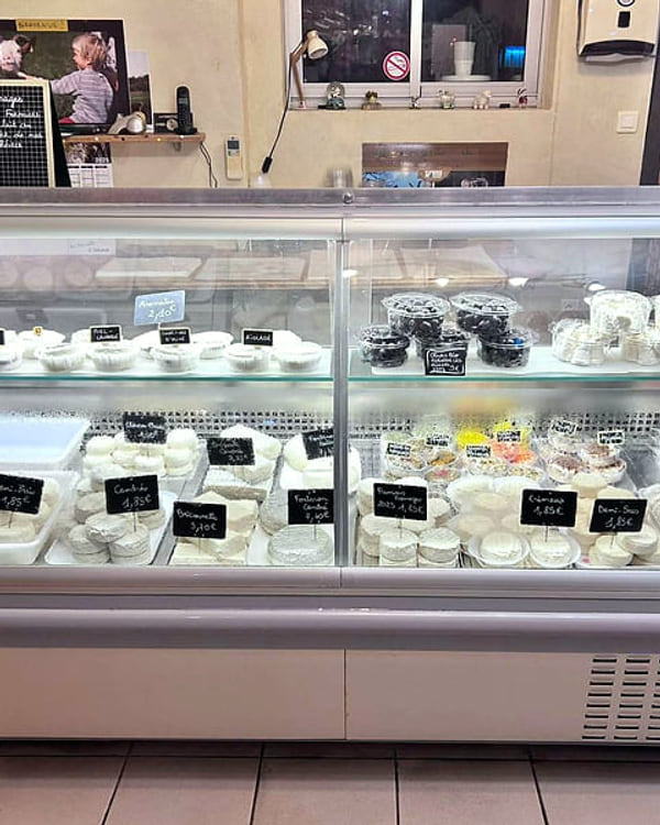 La vitrine du magasin, avec ses fromages et ses étiquettes ardoise